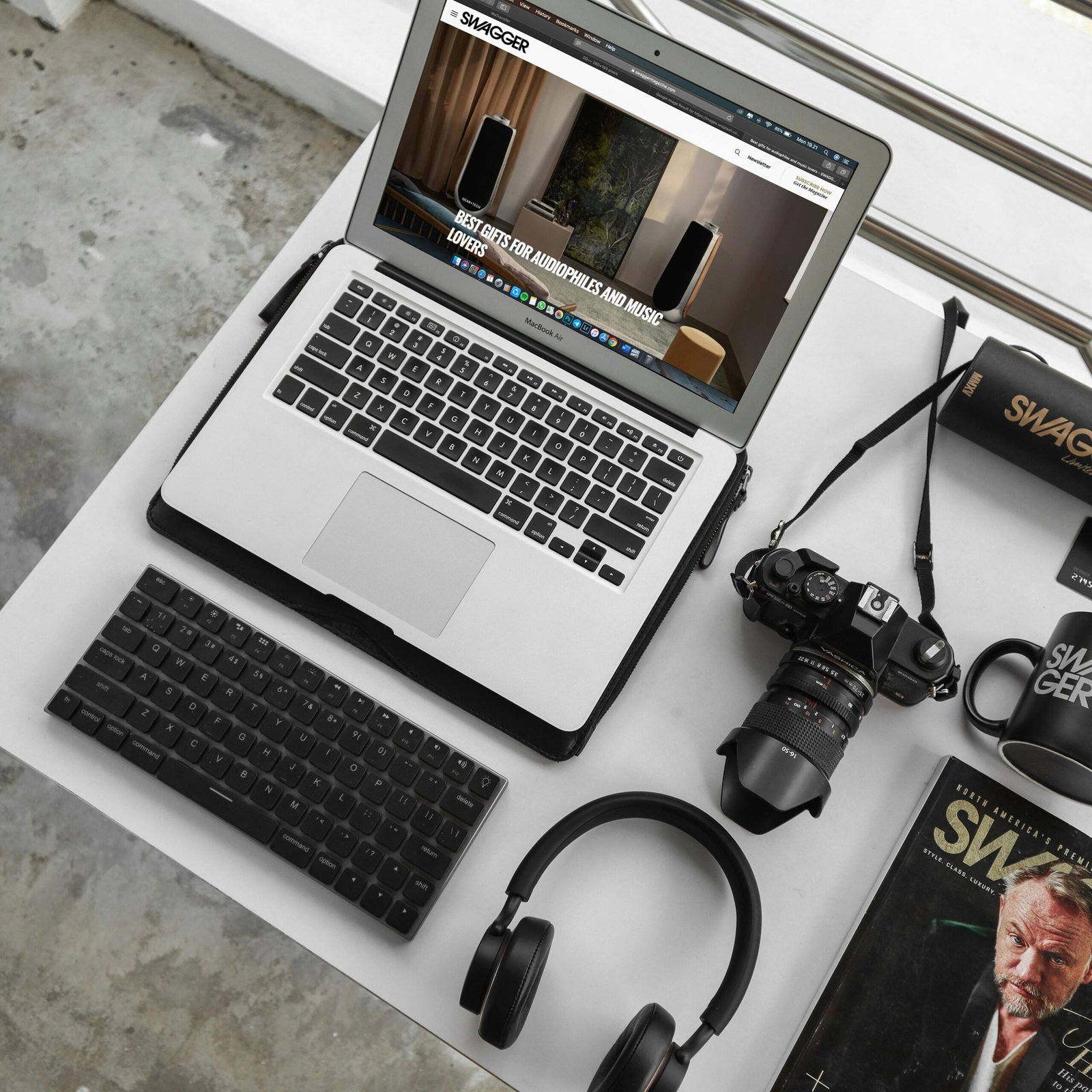 Overhead view of a modern workspace featuring a laptop, camera, and accessories.
