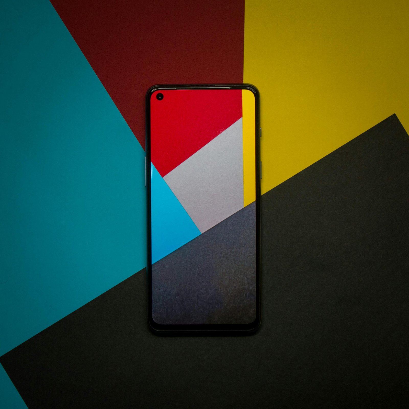 Abstract smartphone display with colorful geometric paper background, capturing modern technology themes.